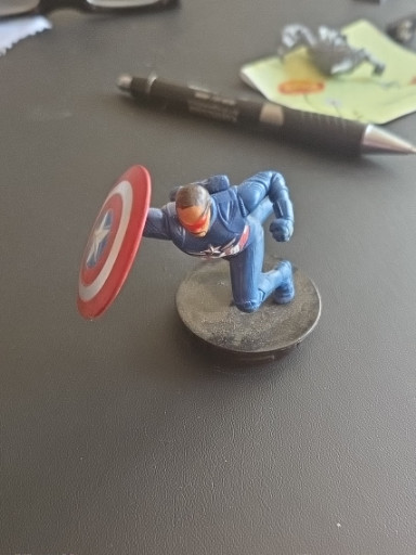 PVC figurine of Captain America in defensive kneeling pose with shield