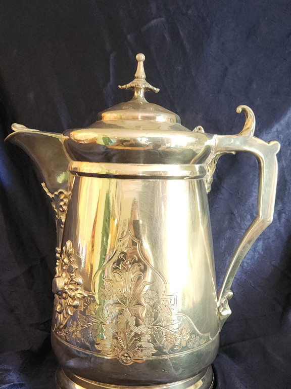 Heavy silver-plated coffee pot with ornate floral embossing. By J A Stimpson. Patented for an additional seven years in 1854