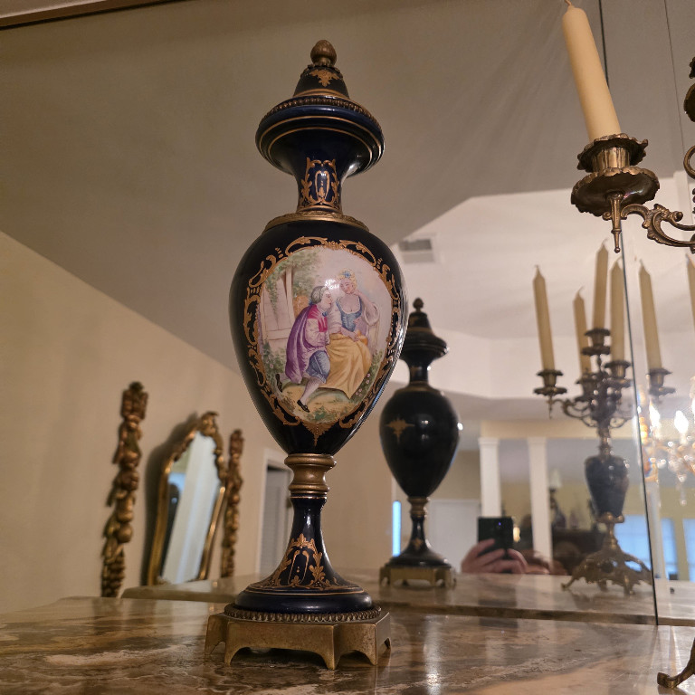 Pair of cobalt blue porcelain urns with hand-painted romantic scenes and gilt decoration