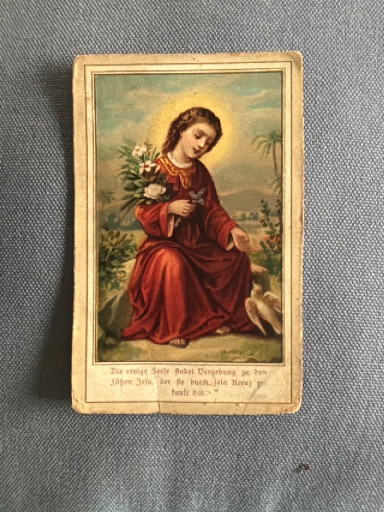 Antique chromolithograph holy card depicting a saint with flowers and a lamb