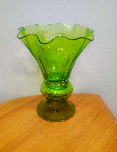 Green glass vase with ruffled rim and pedestal base