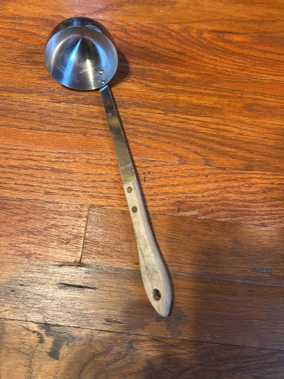 Stainless steel ladle with wooden handle and brass rivets