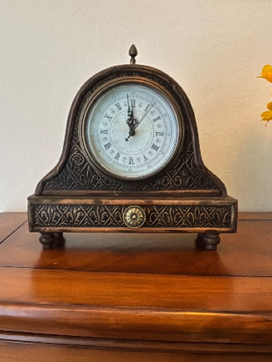 Resin mantel clock with ornate decorative wooden case.