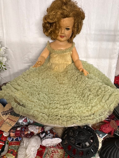 Vintage 1950s bride doll with vinyl face, sleepy eyes, and original green dress