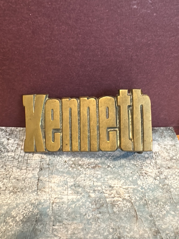Brass belt buckle with the name 'Kenneth' in raised block letters