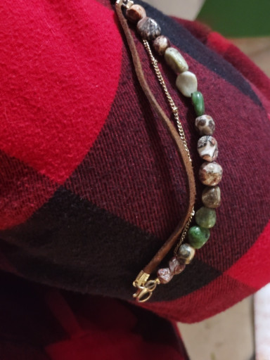 3 Strand bracelet with 1 Gemstone 1 gold-tone chain and 1 leather cord .