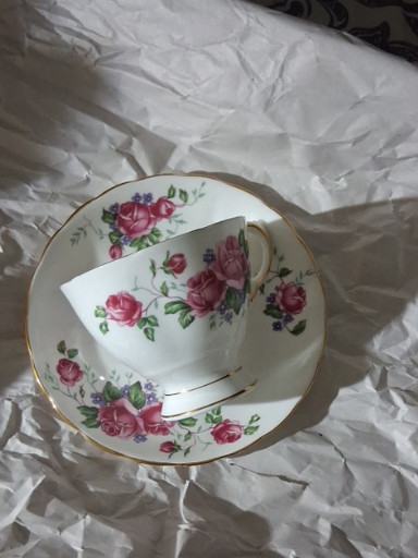 Fine bone china teacup and saucer with pink rose pattern and gold trim