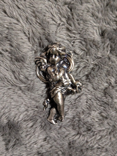 Sterling silver repoussé brooch depicting a cherub or putti figure