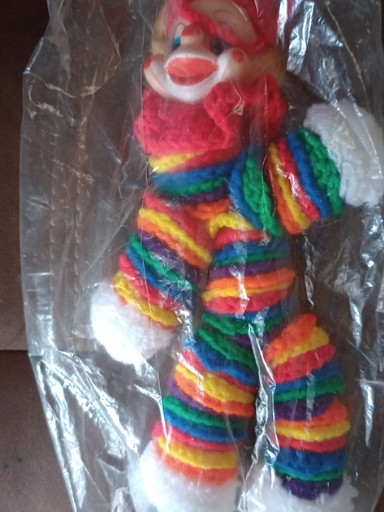Handmade crocheted clown doll with vinyl face and rainbow-striped yarn body