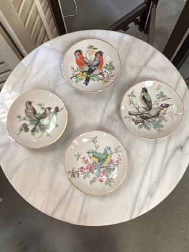 Set of four porcelain miniature decorative plates with hand-painted bird motifs and gold trim, made in Japan