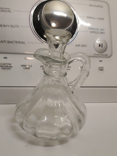 Clear pressed glass cruet with ribbed body and glass stopper, likely by Anchor Hocking