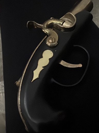 Antique flintlock pistol with brass hardware and black stock