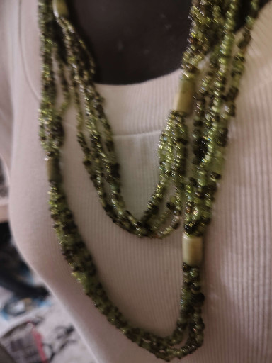 Multi-strand beaded necklace with green seed beads and shell accents