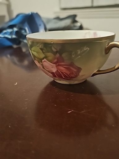 Hand-painted porcelain teacup with pink rose decoration and gold rim