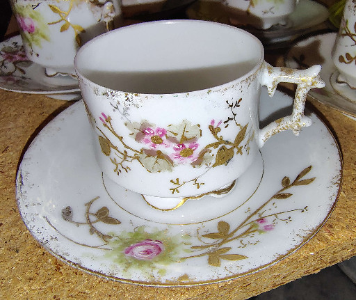 Porcelain demitasse cup and saucer with hand-painted floral decoration by Limoges, France