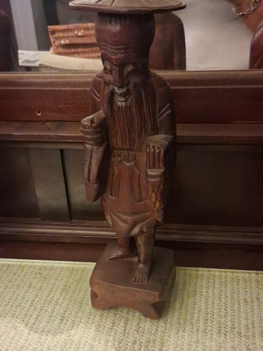Carved wood figurine depicting an elderly Asian man with a wide-brimmed hat