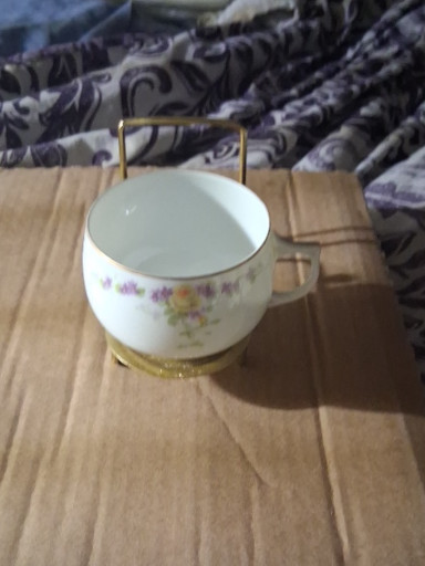 Porcelain teacup with floral decoration and gold trim