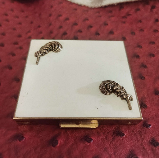 White enamel powder compact with gold-tone feather accents by Schloss & Hausmann