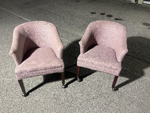Pair of upholstered barrel chairs with pink mauve fabric, mahogany frame and oversized brass casters. made by Sherrill