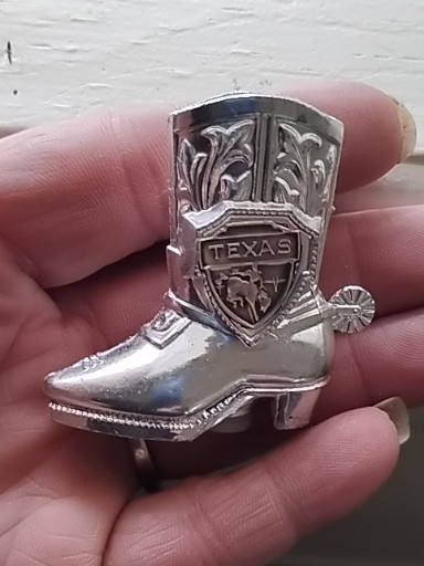 Metal souvenir salt or pepper shaker in the shape of a cowboy boot with 'Texas' emblem