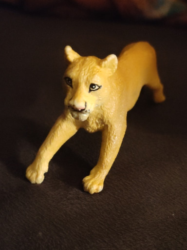 Plastic toy figurine of a running lioness by Safari Ltd.