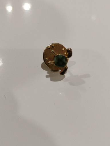 Gold-tone cufflink with carved green jade or jasper stone, likely by SWANK