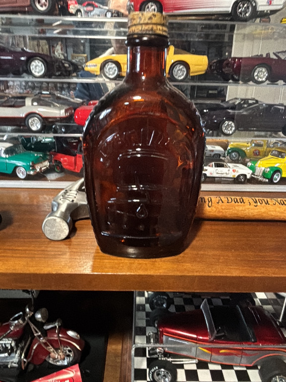 Amber glass bottle embossed with Liberty Bell and 'Log Cabin Syrup' commemorative design