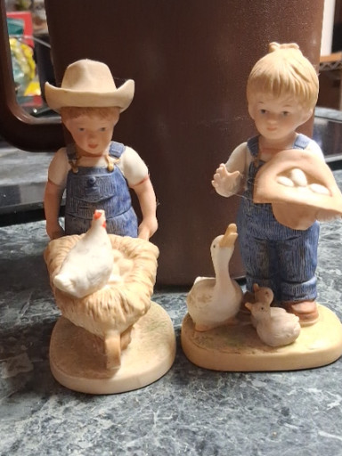 Pair of porcelain figurines from the 'Denim Days' collection by Homco, depicting children with farm animals