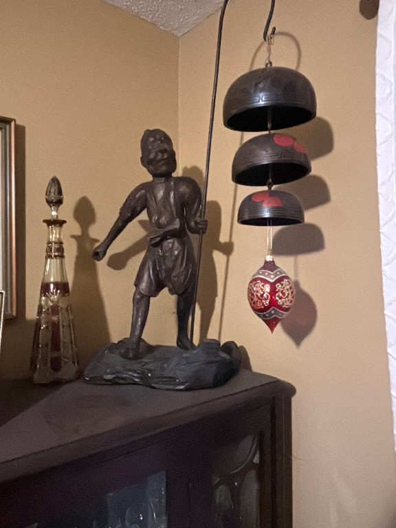 Wooden carved fisherman figure with Asian-style wind chime from China