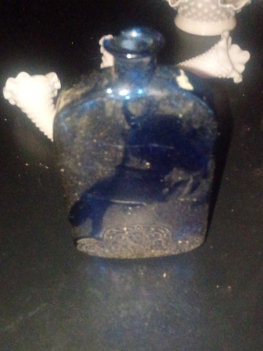 Cobalt blue glass bottle with embossed floral motif on base