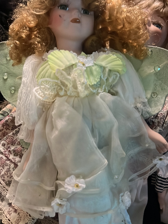 Porcelain fairy doll with green wings and white dress