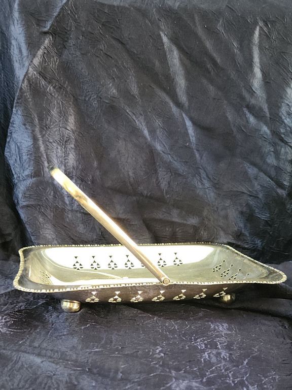 Silver-plated pierced basket on four balled feet with a swing handle. EPNS (Electroplated Nickel Silver). Made in England by Cheltenham and Co. LTD.