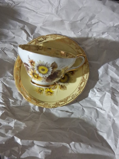 Bone china teacup and saucer with sunflower floral design and gold trim