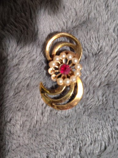 Gold-tone metal brooch with faux pearls and red rhinestone center