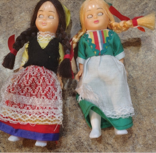 Pair of vintage plastic nationality dolls with sleeping eyes, representing traditional European folk costumes