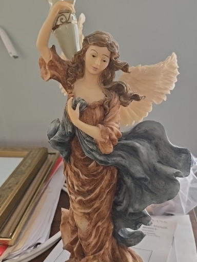 Resin angel figurine holding an ewer