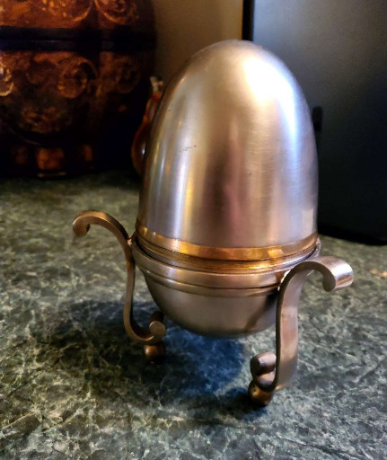 Brushed steel and brass egg-shaped box on brass paw-footed stand