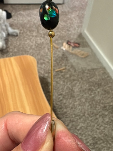 Gold-tone stick pin with black glass cabochon featuring green foil inclusions