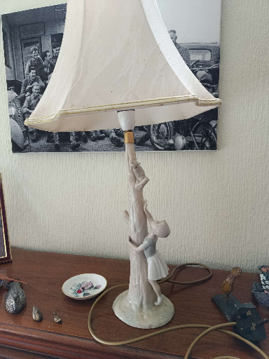 Porcelain figural table lamp depicting a young woman with child reaching upward