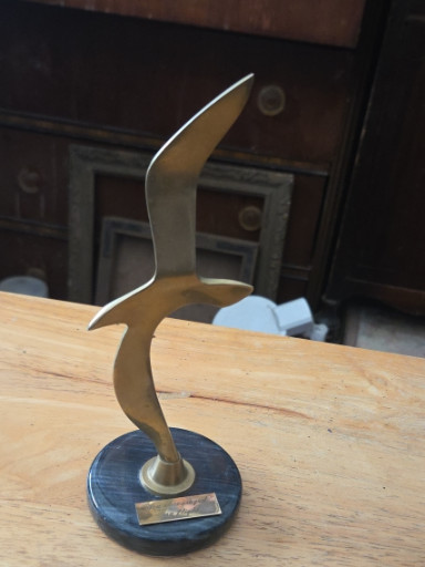 Brass sculpture of a stylized seagull on a marble base