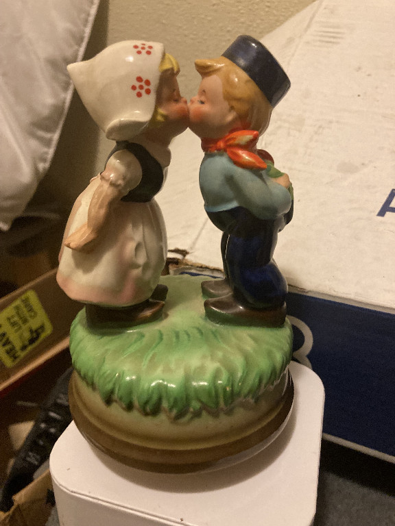 Ceramic music box figurine depicting a Dutch boy and girl kissing