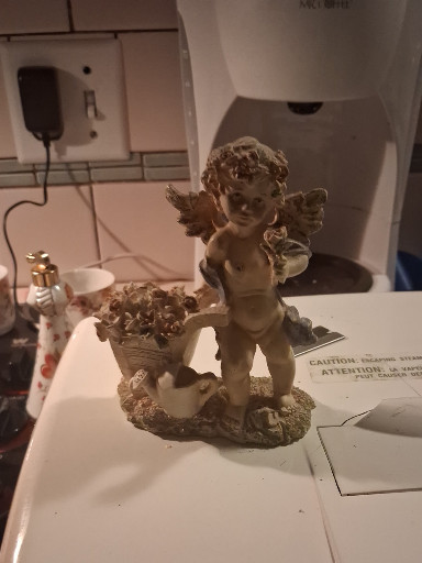 Resin cherub figurine with basket of flowers