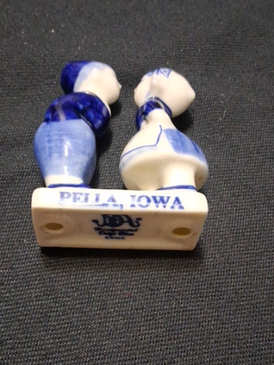Delft-style porcelain figurine depicting a Dutch boy and girl kissing, marked 'Pella, Iowa'