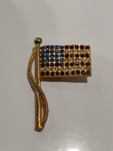 Gold-tone metal American flag brooch with blue, clear, and red rhinestones