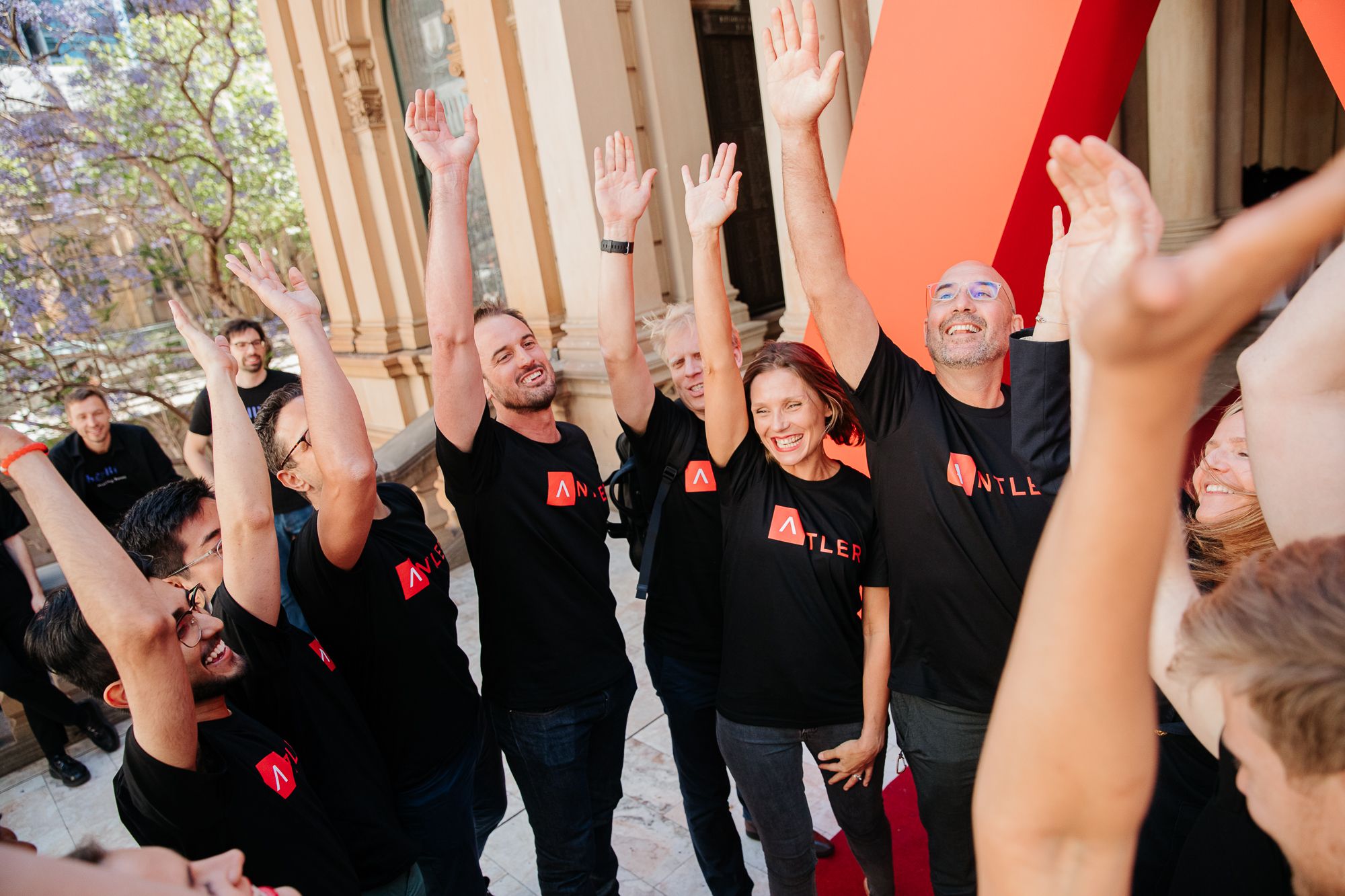 Grupo de fundadores comemora com as mãos levantadas em evento da Antler