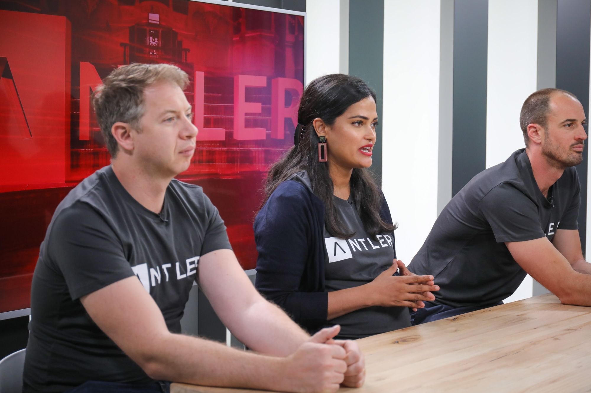 Três fundadores sentados lado a lado durante uma conversa em painel de evento