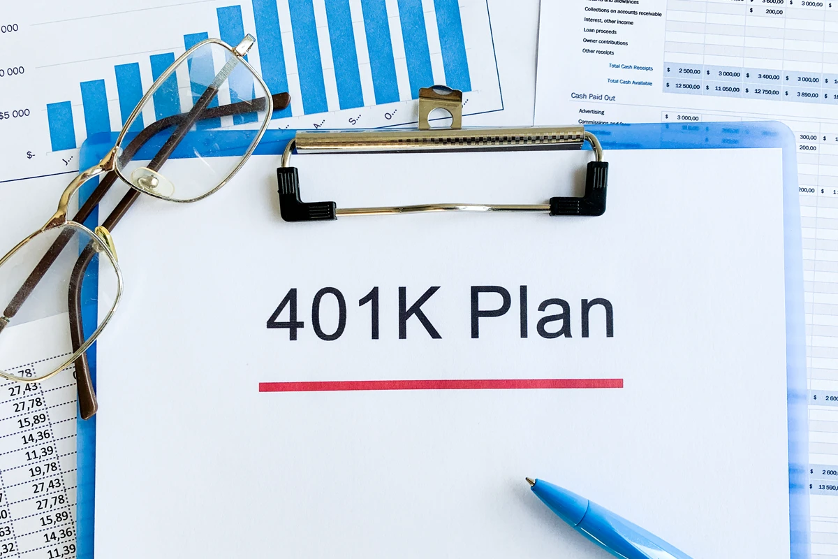 401K plan document with glasses and financial charts