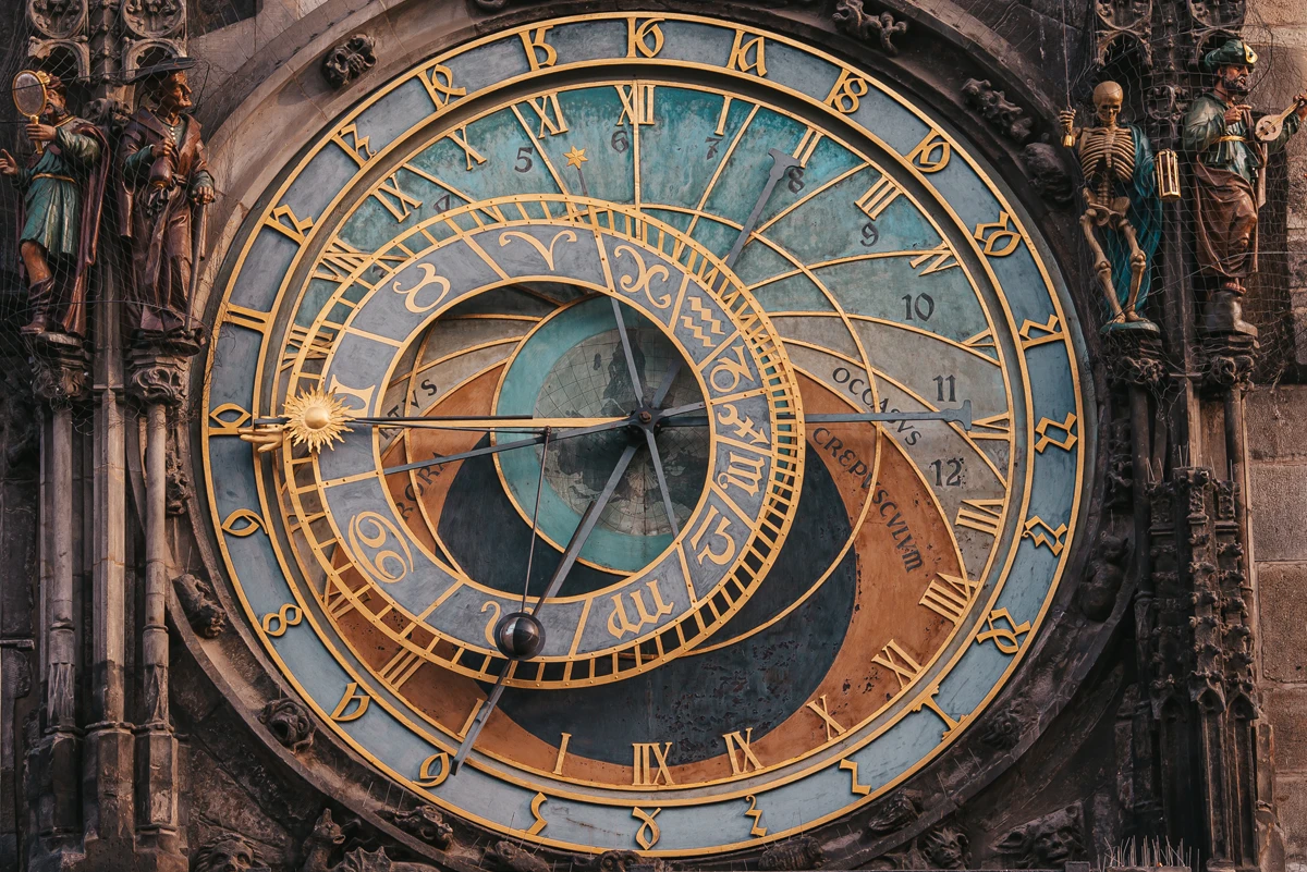 Historic astronomical clock with zodiac signs and statues.