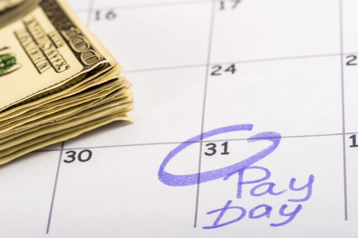 Calendar marked payday with stack of cash