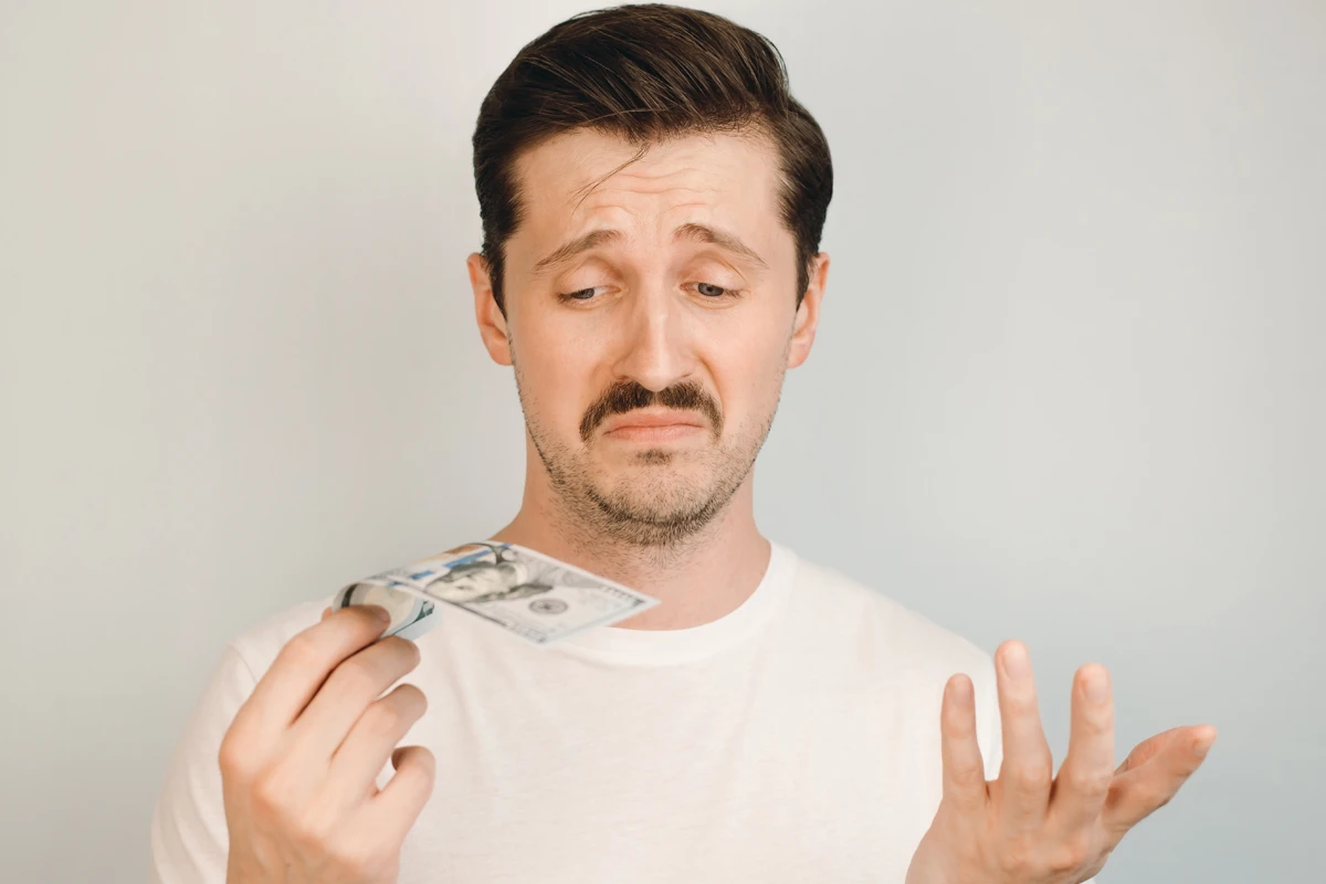 Confused man holding money.